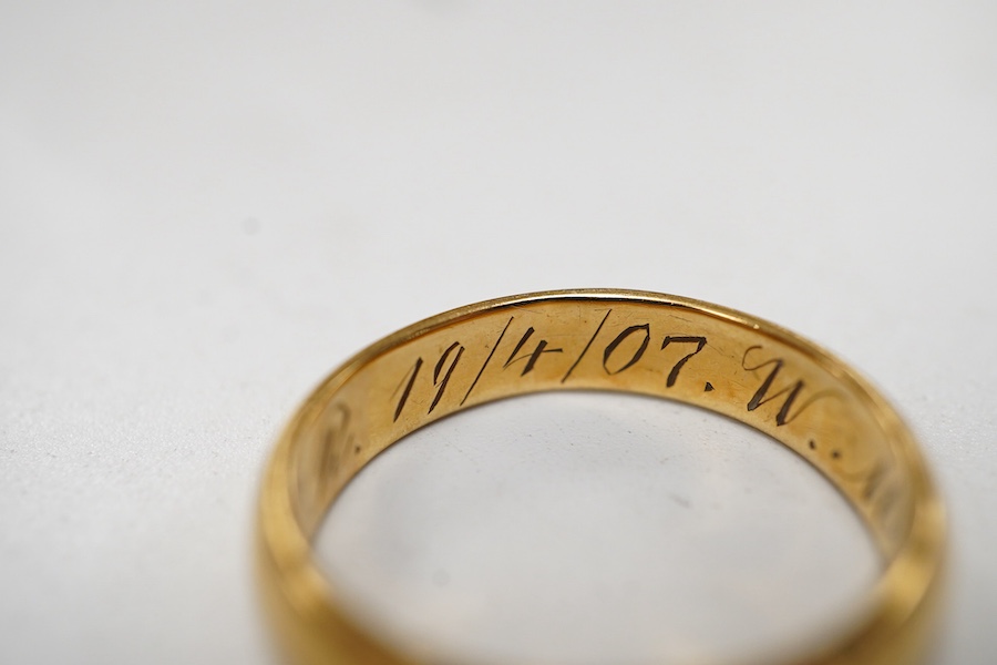 A Far Eastern yellow metal wedding band with engraved inscription, stamped '20', size O, 5 grams.
